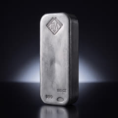 Johnson Matthey 100 oz silver bar turned slightly to show its thick smooth side and the front stamps